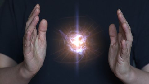 Woman praying, creates and holds a clot of vital energy in her palms. Glowing lights in woman hands. Concept of sharing, giving, offering, taking care, protection.