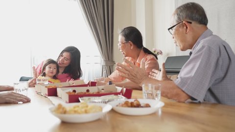 Happy family time and relationship, Asian big family having small party together at home. Pan shot of elder couple with son and daughter talking with fun and smile having dinner on dining table.