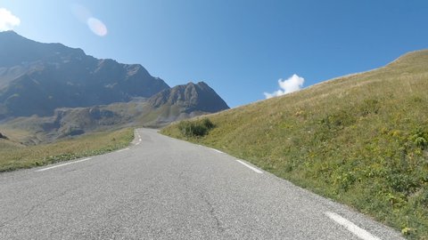 Vehicle point of view footage while driving on the road climbing from the south to the mountain pass Galibier in the French Alps.