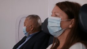 4K: Airplane Passengers wearing Face masks whilst social Distancing on plane. Air Travel. Stock Video Clip Footage