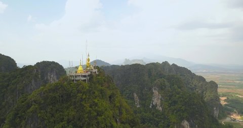 Cinematic Aerial View of Tiger Cave Buddhist Temple and Golden Buddha Statue on Steep Hilltop in Krabi Province, Thailand