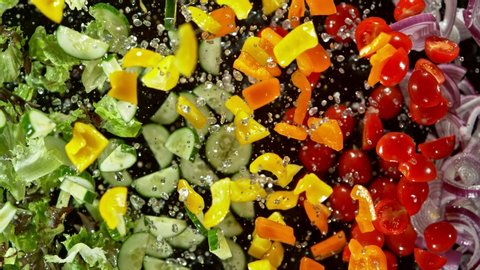 Super Slow Motion Shot of Flying Cuts of Colorful Rainbow Vegetables and Water Drops at 1000fps.