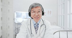 Telemedicine concept - asian senior male senior doctor talking symptom to patient on the internet and make a discussion with ok gesture in hospital