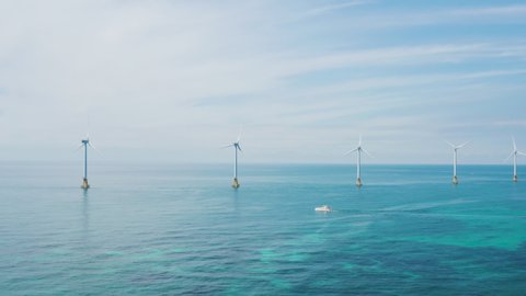 Beautiful scenery of wind turbines installed on the blue sea. Jeju island.
