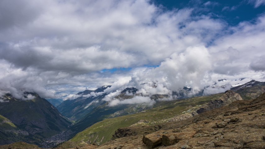 Timelapse Of Thick Clouds Soaring Over The Zermatt Village In Switzerland With Patches Of Fog On A Sunny Day - high angle shot