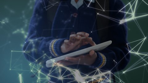 Animation of network of connections with icons and schoolboy using a digital tablet in classroom in the background. Education and schooling concept digital composite.