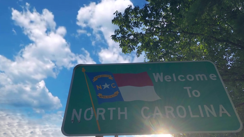 Time lapse clouds over state sing of Welcome to North Carolina. High quality 4k footage. State line sign for North Carolina entrance. | Shutterstock HD Video #1057085594