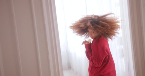 Black woman singing into hairbrush, dancing and shaking hair