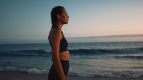 Portrait of woman deeply breathing and meditating at beach, closed eyes, mind setting for training, sunset at coast of Pacific Ocean