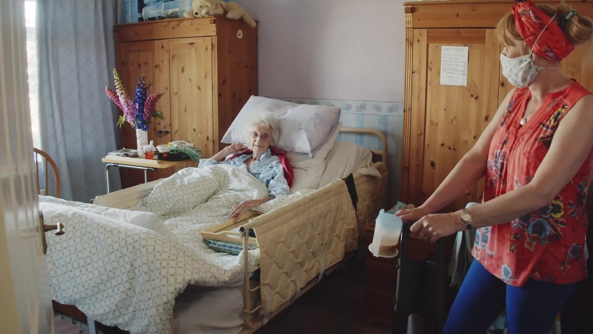 A care worker talks to a patient whilst keeping a safe distance under C019 guidelines | Shutterstock HD Video #1057091435