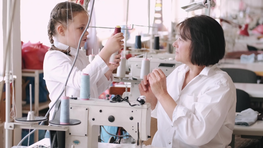 Grandmother with granddaughter at the factory. Family with a fabric.