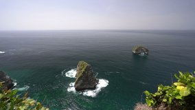 Nature landscape with mountain in sea and rocks. Amazing mountain cliff in the azure ocean water against the backdrop of beautiful tropical nature. Bali, Indonesia