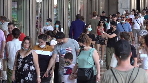 MILAN, ITALY - 4 JULY 2020: Crowds of people wearing face mask walk through popular shopping street in Milano, Covid-19 coronavirus regulation in Italy