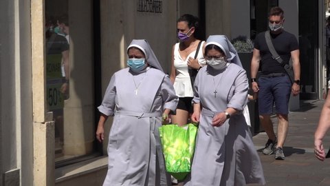 BERGAMO, ITALY - 4 JULY 2020: Two Catholic nuns wearing face masks walk through shopping street in Bergamo, the hardest hit region in Europe by the novel Covid-19 coronavirus (slow motion)