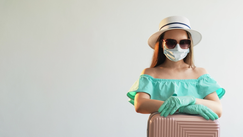 COVID-19 prevention. Delayed flight. Woman with suitcase isolated on gray copy space. Pandemic health protection. Stay home. Summer vacation Royalty-Free Stock Footage #1057101299