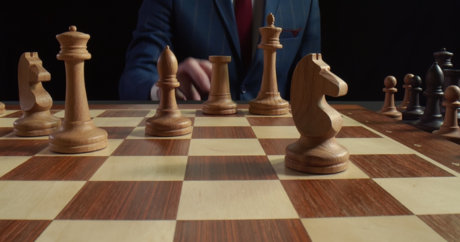 Close up of man playing chess and making move with white rook isolated on black background. Businessman making strategic move in chess game. Intellectual hobby, strategy concept Royalty-Free Stock Footage #1057132577
