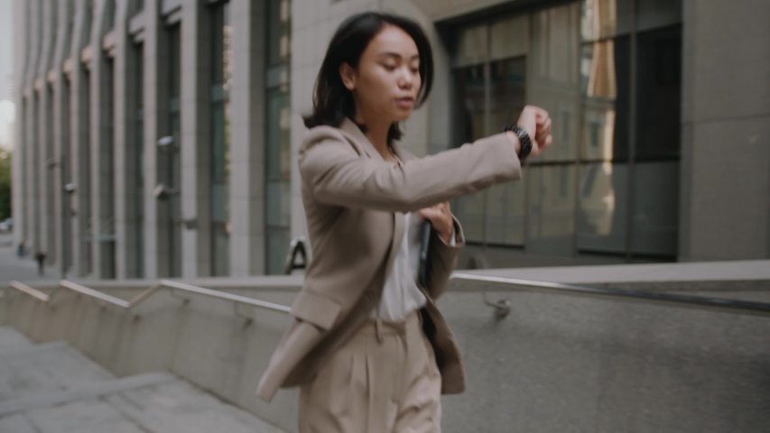 Young asian beautiful businesswomen on hurry walking on stairs look at watch running city female stairway step suit time job smart concept young slow motion