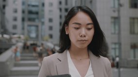 Smiling asian young woman in formal outfit looking to camera outside on street feel happy businesswoman portrait business beautiful modern manager pretty slow motion