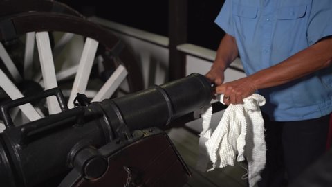 the man loading the cannon with the fabric for a blank shot. a volley of ancient weapons.