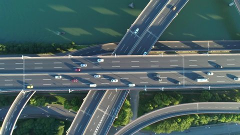Aerial drone view of highway multi-level junction road with moving car at sunset. Active movement of transport cars vehicles in different directions.The concept of the urban. China. Top down view.