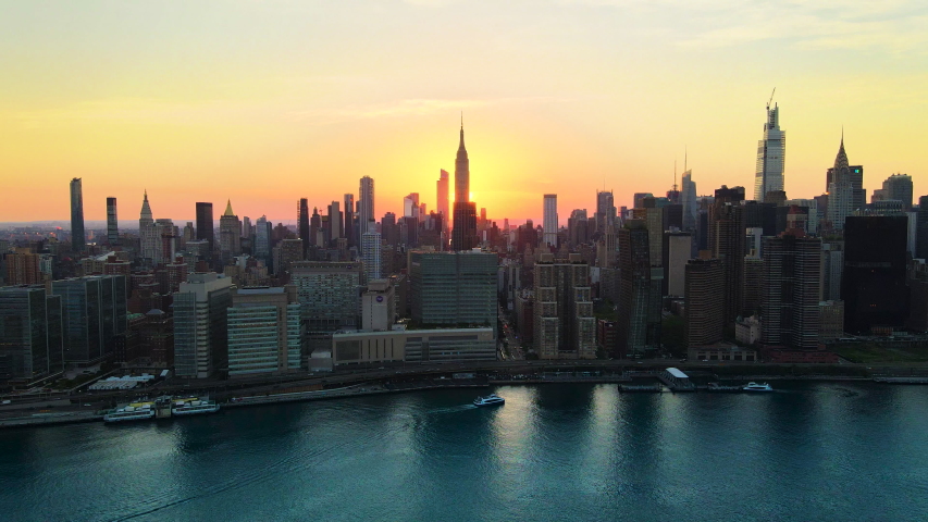Unique Manhattanhenge 2020 aerial shoot, revealing the golden light of the streets of Midtown New York aligned with the Sun. Royalty-Free Stock Footage #1057146545