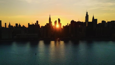 Skyscrapers' Silhouette, aerial sliding shoot of New York City at golden hour, with the Sun crossing the city from one side to another. Adlı Stok Video
