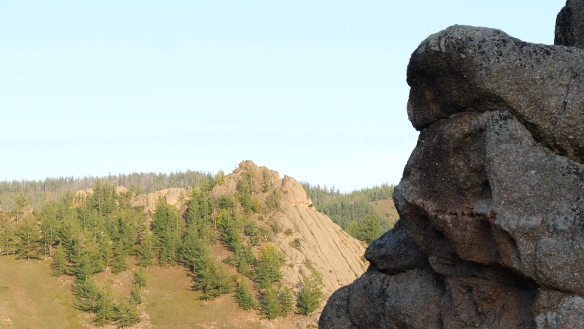 Gorkhi-Terelj National Park. The Mongolian landscape. Picturesque rocks in the light of the setting sun against a blue cloudless sky.