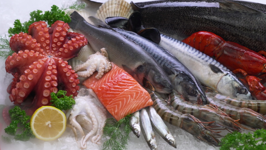 Top view of variety of fresh fish and seafood on ice with dry ice smoke. Royalty-Free Stock Footage #1057147916