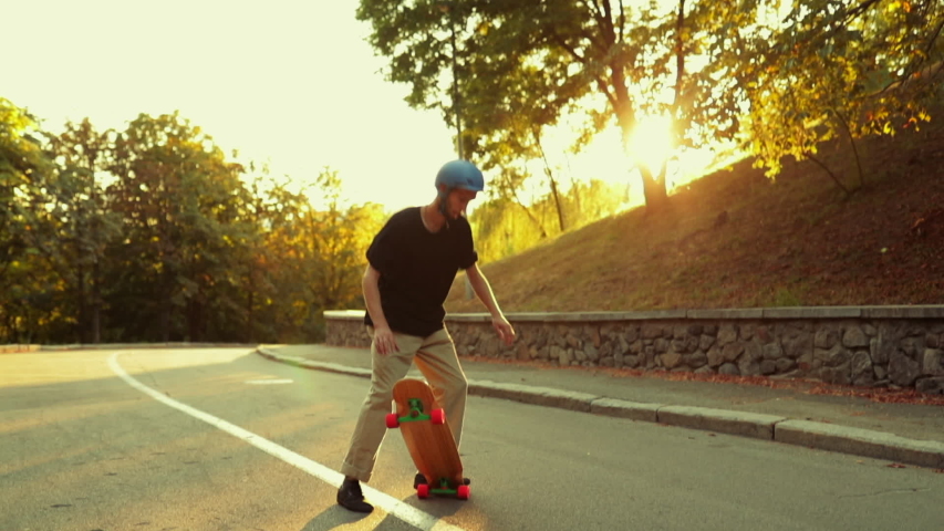 The guy spins on a longboard at sunset. High quality FullHD footage