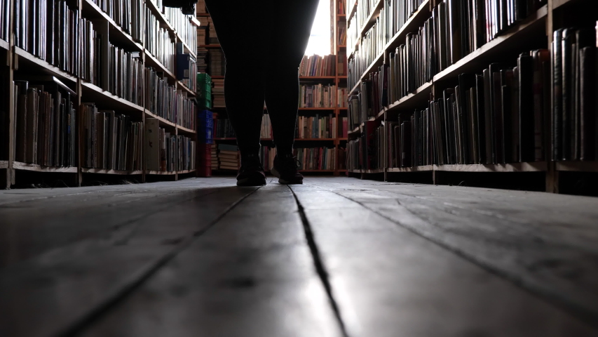 Low Shot Walking On Hardwood Floor Through Bookstore Dim Slow motion