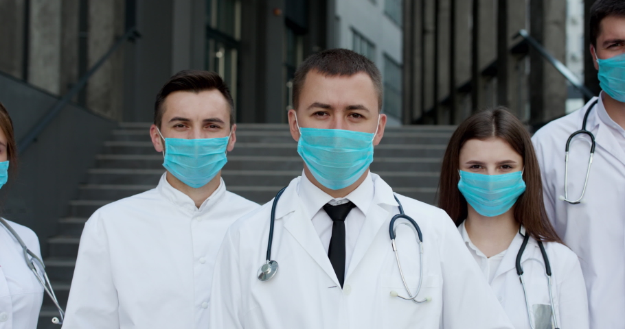 Group of Doctors With Face Masks Looking at Camera. Teamwork Specialist Doctors . Corona Virus and Healthcare Concept. Royalty-Free Stock Footage #1057160659