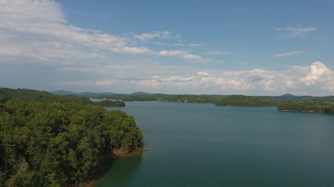 Aerial flying over Lake Keowee in Upstate South Carolina in summer . High quality 4k footage. Drone flying over lake in upstate SC in summer with recreations boats on lake.