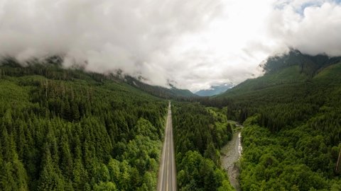 Cinemagraph Continuous Loop Animation. Aerial View of a scenic Highway surrounded by Canadian Mountain Landscape during a summer morning. Taken in Northern Vancouver Island, British Columbia, Canada.