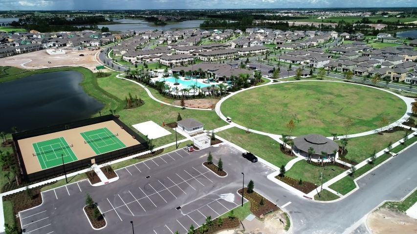 Aerial view of an upper middle class lakefront neighborhood subdivision with single family homes and townhouses, pool and clubhouse on a cloudy fall day in Winter Garden, Florida, USA.