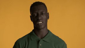 Young disgusted African American man unpleasantly looking in camera over colorful background