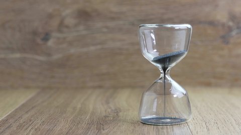 closeup modern hourglass with black sand, 30 seconds countdown