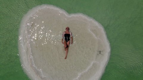 Journey to the shores of the Dead Sea. Shooting from the drone. bather relaxing on a heart-shaped island in the Dead Sea. High quality 4k footage