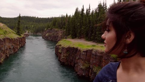 Indian woman looks out onto Yukon River at Miles Canyon, close up
