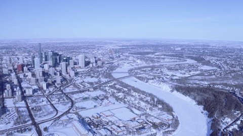 Stunning aerial Winter Snow covered cityscape of downtown Alberta Edmonton Capital city. Panaromic view of the Saskatchewan river, & 3 bridges that connect to the downtown core. Clear sky high above