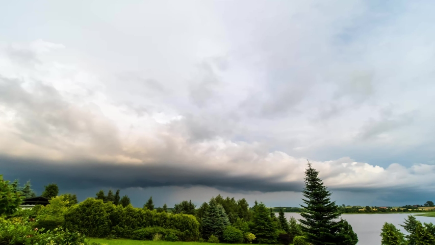 Time Lapse of Storm Clouds Ghatering over Trees and Lake.