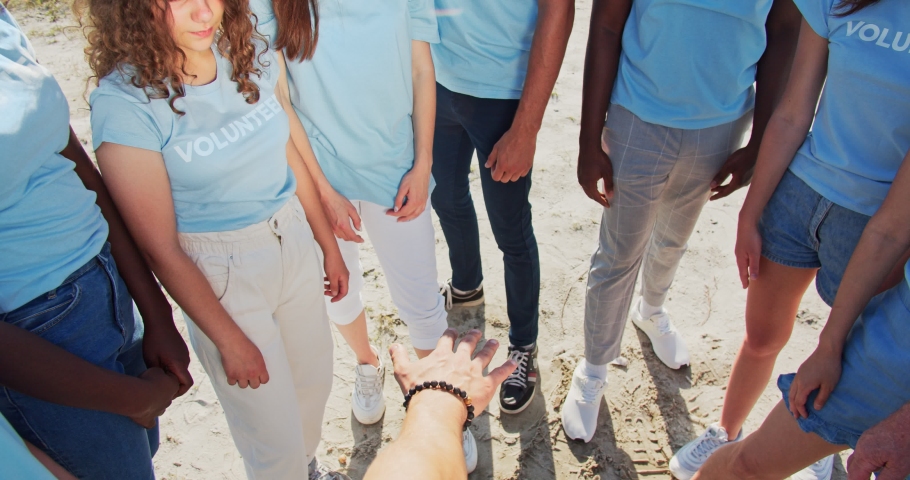 People of different ages and races are united to protect environment from pollution. Happy volunteers stacking hands together to cheer and boost team spirit. Friendship, teamwork, volunteering. Royalty-Free Stock Footage #1057206763