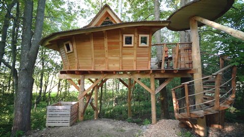 Zoom out FHD shot of a luxurious wooden tree house accommodation at an outdoor campsite in a forest in Dolní Morava, Czech Republic. Luxurious wooden tree house in a forest in Czechia.