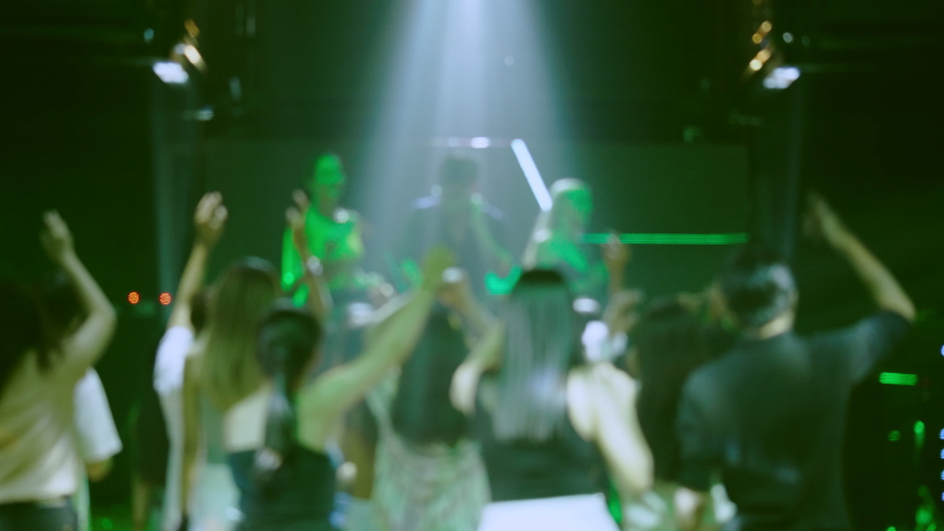 Blurred version of footage. Group of people happy dancing come celebrate concert party in entertainment venue. DJ play fun music in nightclub. End of quarantine and return to open Business nightlife | Shutterstock HD Video #1057209616