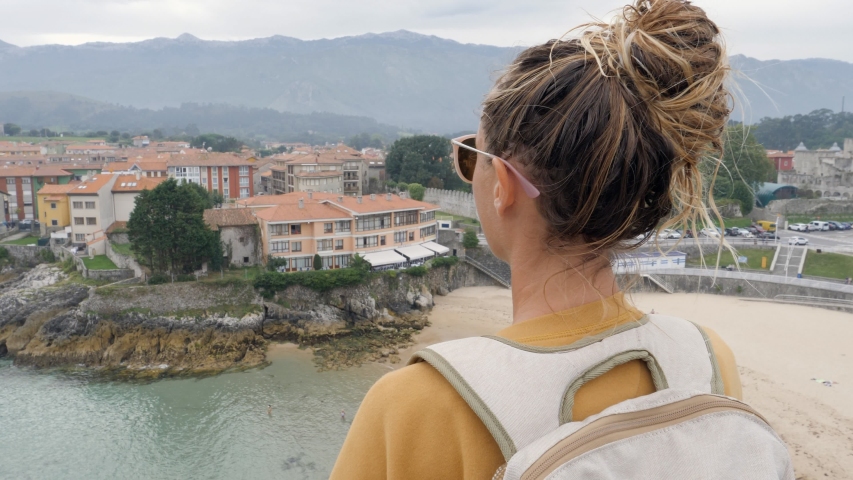 Young traveller makes heart shape finger frame using hands. Woman travelling in Spain visits coastal town and make a heart shape 