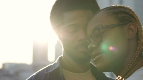 Tender black couple smiling and hugging, happy faces close-up, love in air