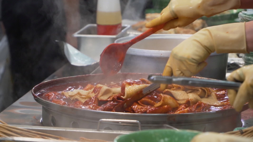 Tteokbokki is the most popular Korean street food. This is a stir-fried rice cake in a spicy red soup. People can see a lot of Tteokbokki shop in Korea. Royalty-Free Stock Footage #1057228555