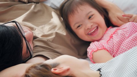 Happy family with mother, father and disabled daughter spending time together at home.	の動画素材