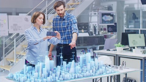 Architect and Engineer have Discussion, Use Augmented Reality Smartphone to Design Sustainable 3D Megalopolis City Model. Futuristic Office with Architectural Designers. Graphical Animation VFX 