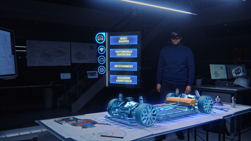 Automotive Engineer Wearing Virtual Reality Headset Working on 3D Electric Car Design, Using Gestures in Augmented Reality He Designs and Manipulates Graphical Parts, Picks Body for the Chassis,Engine Royalty-Free Stock Footage #1057229629
