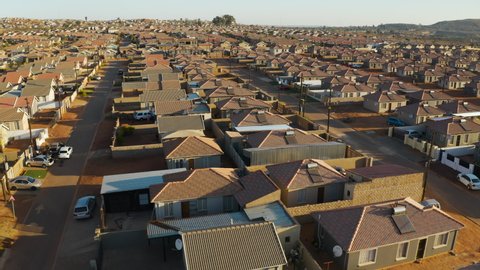Aerial panning view of low cost housing in an African township with solar geysers on the rooftops, South Africa